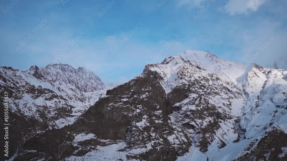 Sunset light on mountain peaks with clouds in sky at sunset in Lahaul, India. Snow covered Himalaya mountains landscape. Winter wonderland. Sunset light on mountain peaks with clouds in sky at sunset in Lahaul, India. Snow covered Himalaya mountains landscape. Winter wonderland.