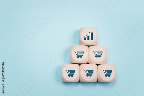 Sale volume increase make business grow concept. Sale growth and ecommerce marketing growth. Wooden blocks with growth graph icon and shopping cart symbol.