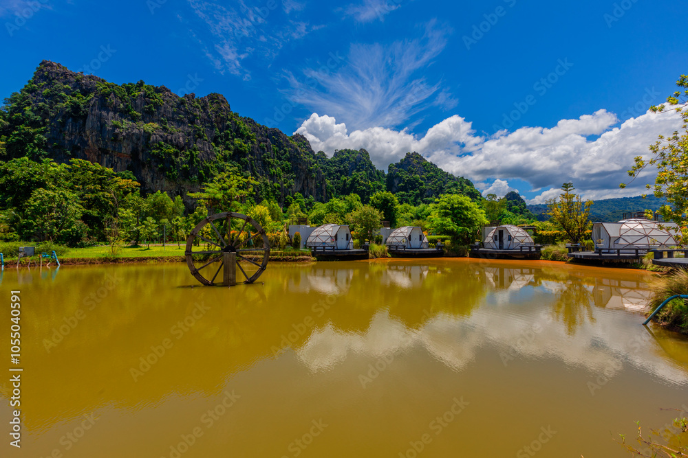 Obraz premium The natural background of the camping ground has chairs to sit and enjoy the natural view. The air is fresh and the atmosphere is surrounded by trees and big mountains.