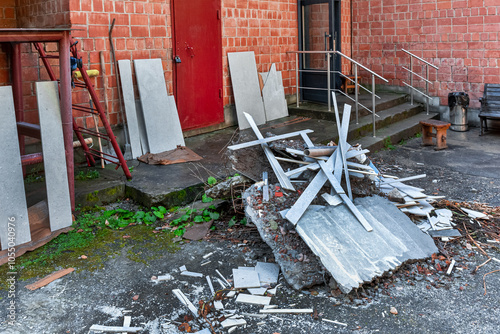 A pile of construction debris from the repair work lies next to a brick building.	