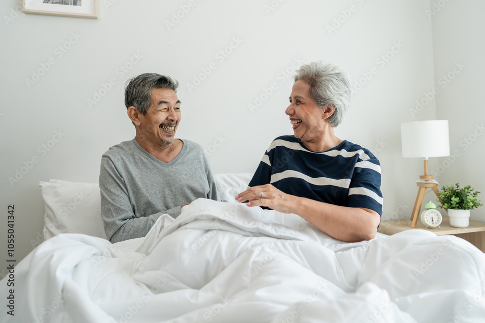 Obraz premium Asian elderly older couple lying down on bed in bedroom at home in morning. 