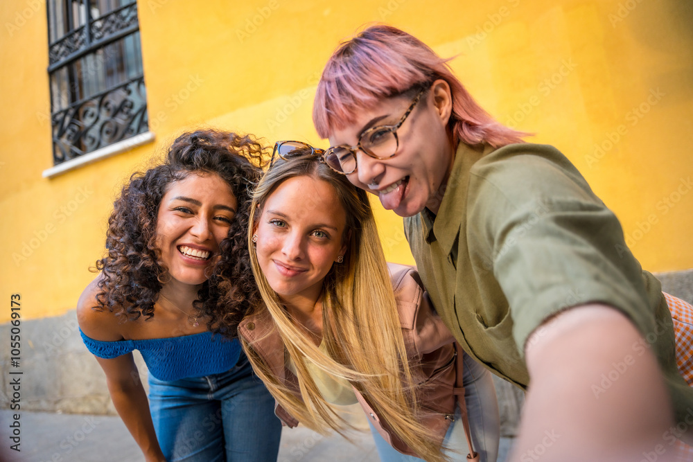 Fototapeta premium Happy friends grimacing while taking selfie in the street