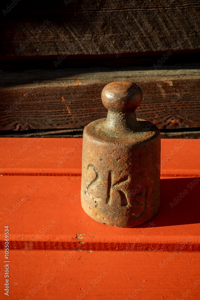 Fototapeta premium rusty old two kilogram weight in sunlight outdoors