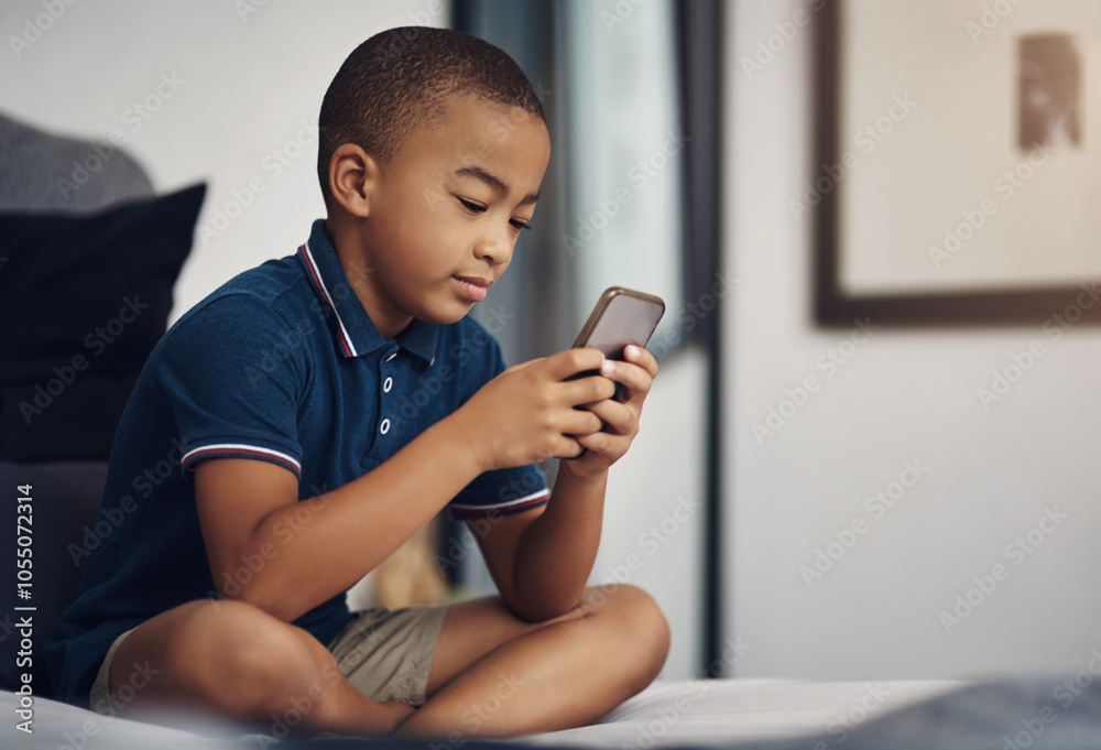 Boy, bedroom and smile with smartphone for video games, entertainment and subscription at home. Male person, kid and concentrate in bed on internet or online with streaming for child development Boy, bedroom and smile with smartphone for video games, entertainment and subscription at home. Male person, kid and concentrate in bed on internet or online with streaming for child development