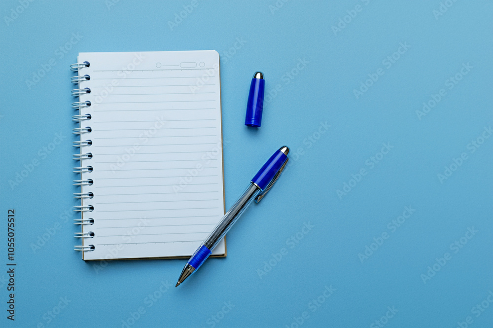 Spiral notebook on blue background, ballpoint pen. Spiral notebook on blue background, ballpoint pen.