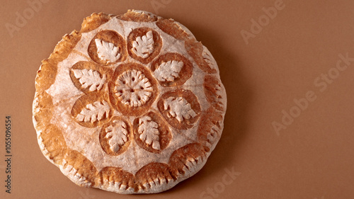Картината върху платно Top view of fresh bread with a floral pattern on a brown background