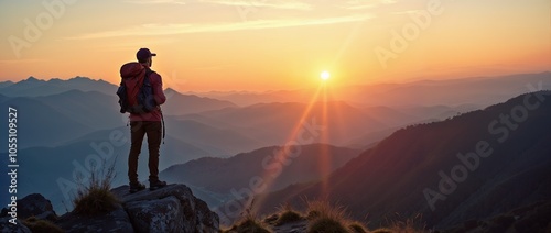 Hiker standing on top of a mountain and looking at the sunrise photo