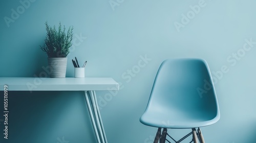 A blue chair sits in front of a white desk with a plant and pencils in a minimalist room.