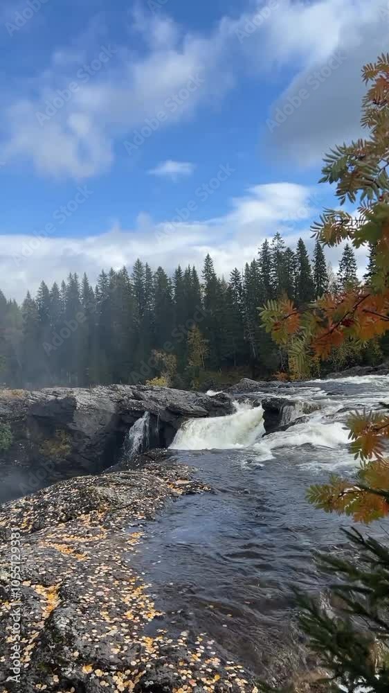 A serene river flows past a waterfall, framed by lush trees in the background, creating a tranquil natural scene. A serene river flows past a waterfall, framed by lush trees in the background, creating a tranquil natural scene.