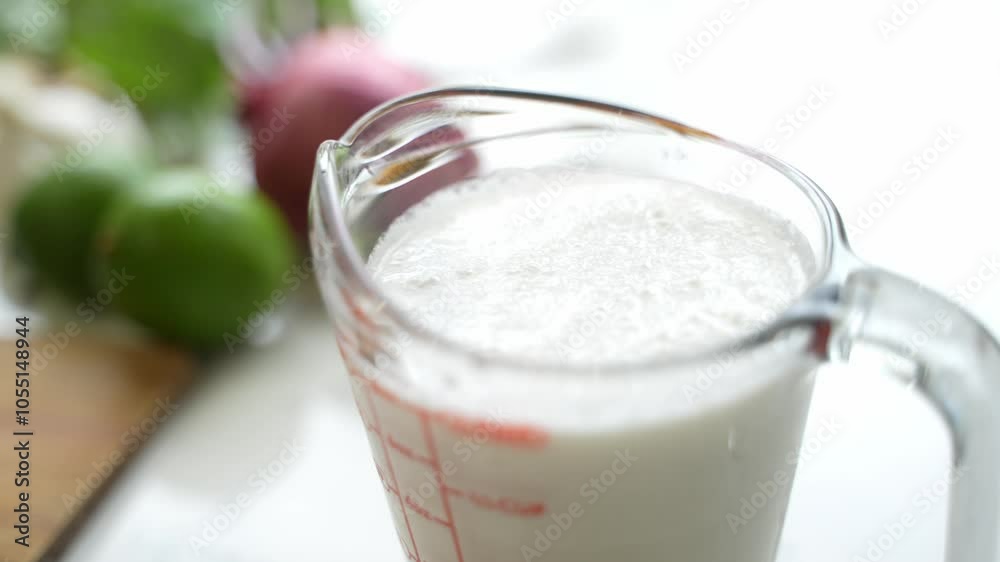 Close up of measuring cup on kitchen counter wtih heavy cream for sauce, meal preparation for cooking Close up of measuring cup on kitchen counter wtih heavy cream for sauce, meal preparation for cooking