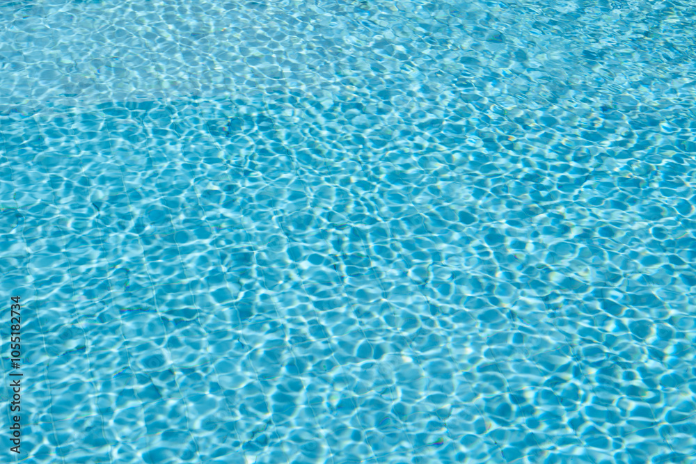 Swimming pool rippled water background, Blue swimming pool water with sun reflections Swimming pool rippled water background, Blue swimming pool water with sun reflections