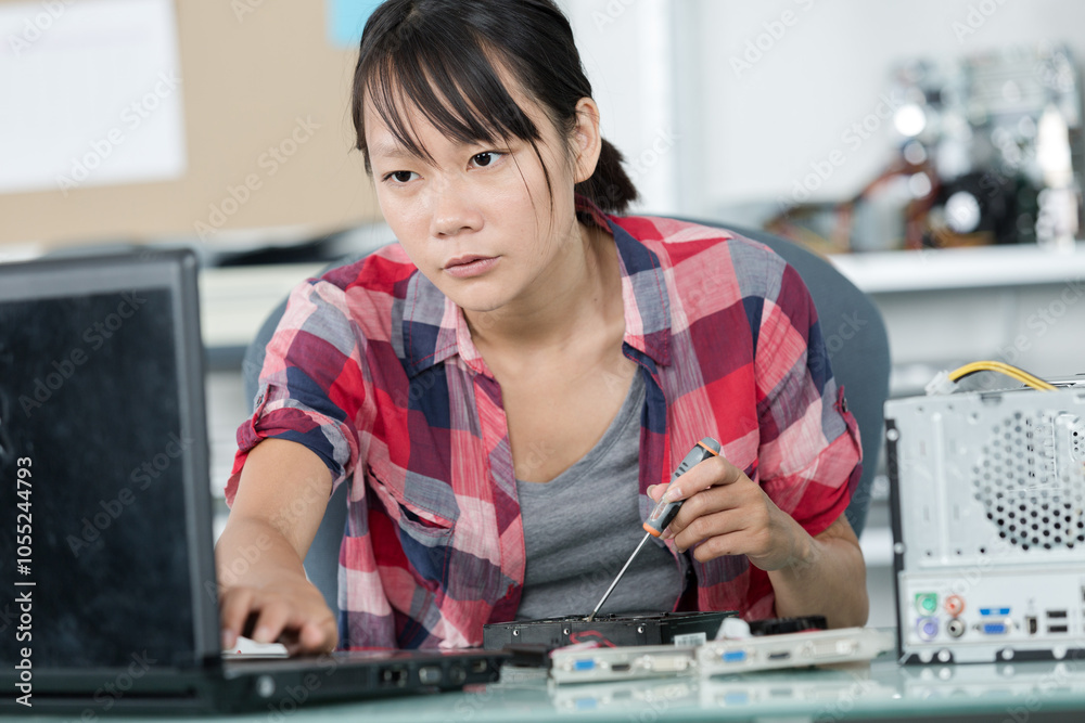 young woman fixing a computer young woman fixing a computer