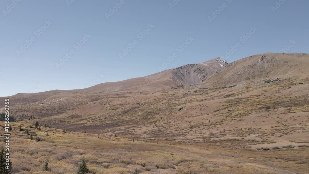Aerial view of a high alpine valley in the fall with mountain peaks in the distance. Filmed near Guanella Pass, Colorado during the fall. Panning shot with rotation to the right. Aerial view of a high alpine valley in the fall with mountain peaks in the distance. Filmed near Guanella Pass, Colorado during the fall. Panning shot with rotation to the right.