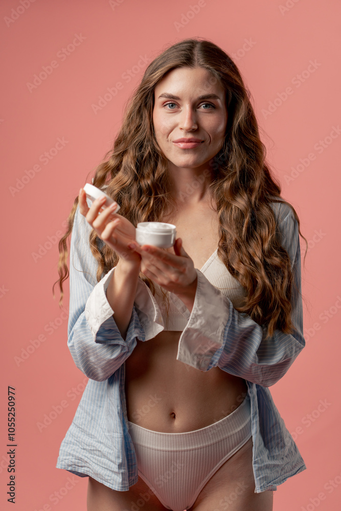 studio beauty shoot on pink background long-haired girl posing in underwear and blue shirt with jar cream natural beauty studio beauty shoot on pink background long-haired girl posing in underwear and blue shirt with jar cream natural beauty