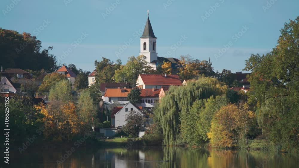 St. Sebastian's and Fabian's Church in Prague stands above the pond surrounded by greenery and small tidy houses. St. Sebastian's and Fabian's Church in Prague stands above the pond surrounded by greenery and small tidy houses.