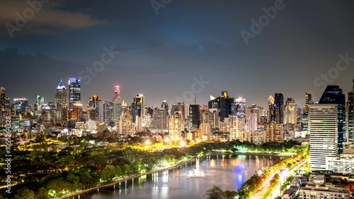 Timelapse of Benchakiti Park in Bangkok, Thailand, with modern skyline and evening lights reflected and sparkling in the water photo