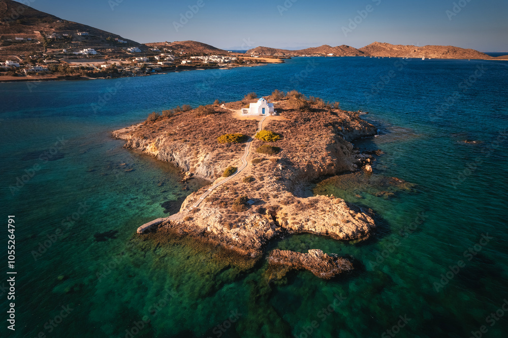 A charming blue-domed chapel on Paros Island, Greece, set against the backdrop of the shimmering Aegean Sea. The whitewashed walls, vibrant dome, and surrounding stone path create a picturesque scene