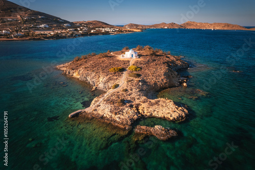 Obraz na płótnie A charming blue-domed chapel on Paros Island, Greece, set against the backdrop of the shimmering Aegean Sea. The whitewashed walls, vibrant dome, and surrounding stone path create a picturesque scene w salonie