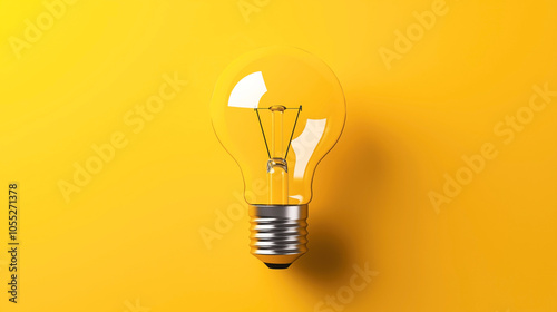 Close-up of a clear incandescent light bulb against a bright yellow background, showcasing the filament and metal base, symbolizing ideas and innovation.