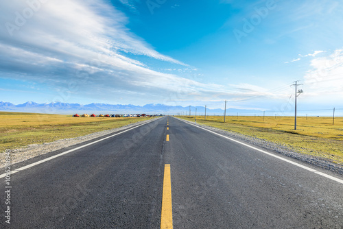 Straight country road and grassland with sky clouds background. Road trip.