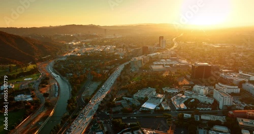 Sunlit scenery of Los Angeles in autumn. Beautiful urban landscape crossed by a busy highway. Top perspective.