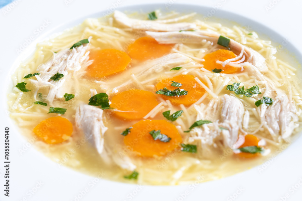 Homemade chicken soup on blue background. Close up