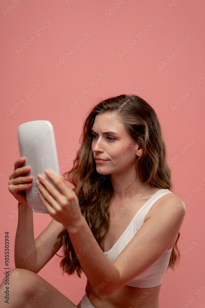 studio beauty shoot on pink background beautiful girl looking in a mirror with LED lighting skin assessment natural beauty imperfect skin positive attitude beauty salon studio beauty shoot on pink background beautiful girl looking in a mirror with LED lighting skin assessment natural beauty imperfect skin positive attitude beauty salon