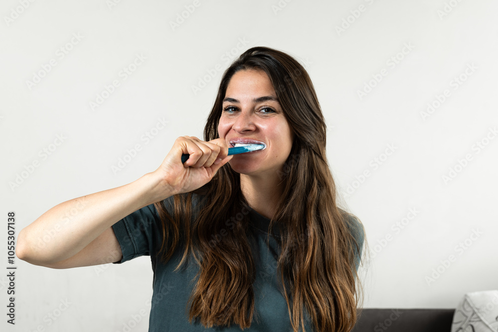 Smiling young woman brushing teeth in bathroom. Happy girl looking in mirror while using ecological toothbrush with whitening toothpaste. Beauty girl in bathroom cleaning teeth in the morning time. Smiling young woman brushing teeth in bathroom. Happy girl looking in mirror while using ecological toothbrush with whitening toothpaste. Beauty girl in bathroom cleaning teeth in the morning time.
