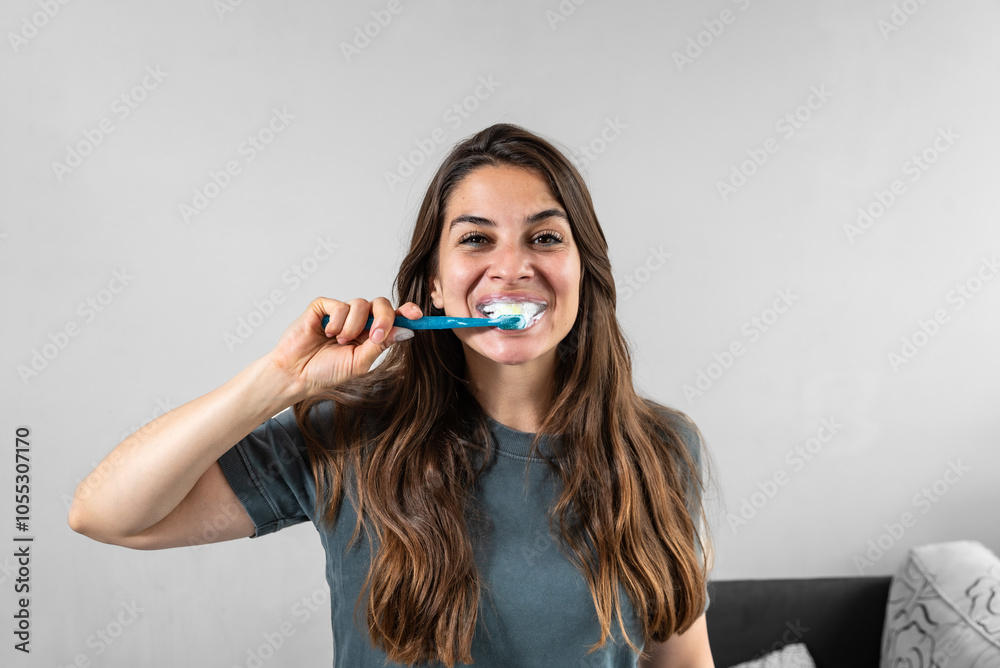 Smiling young woman brushing teeth in bathroom. Happy girl looking in mirror while using ecological toothbrush with whitening toothpaste. Beauty girl in bathroom cleaning teeth in the morning time. Smiling young woman brushing teeth in bathroom. Happy girl looking in mirror while using ecological toothbrush with whitening toothpaste. Beauty girl in bathroom cleaning teeth in the morning time.