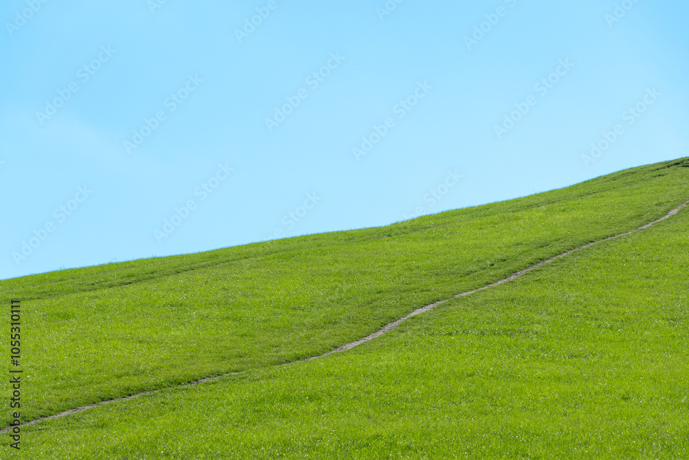 Obraz premium Path on green hill and blue sky.