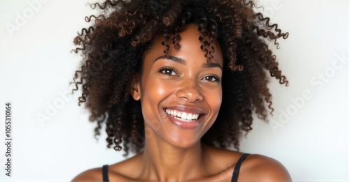 A Caribbean woman with a radiant smile and natural curls