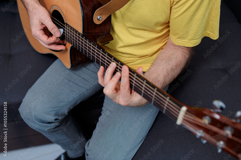 Fototapeta premium Guitarist on acoustic guitar playing melody in studio. Close up musician instrument