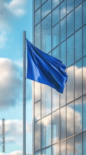 A blue flag mockup flutters on a pole near a reflective glass office building under a blue sky