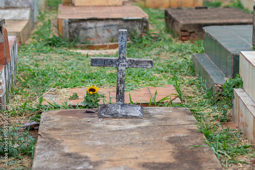 Um túmulo simples com uma cruz de concreto em um cemitério. photo