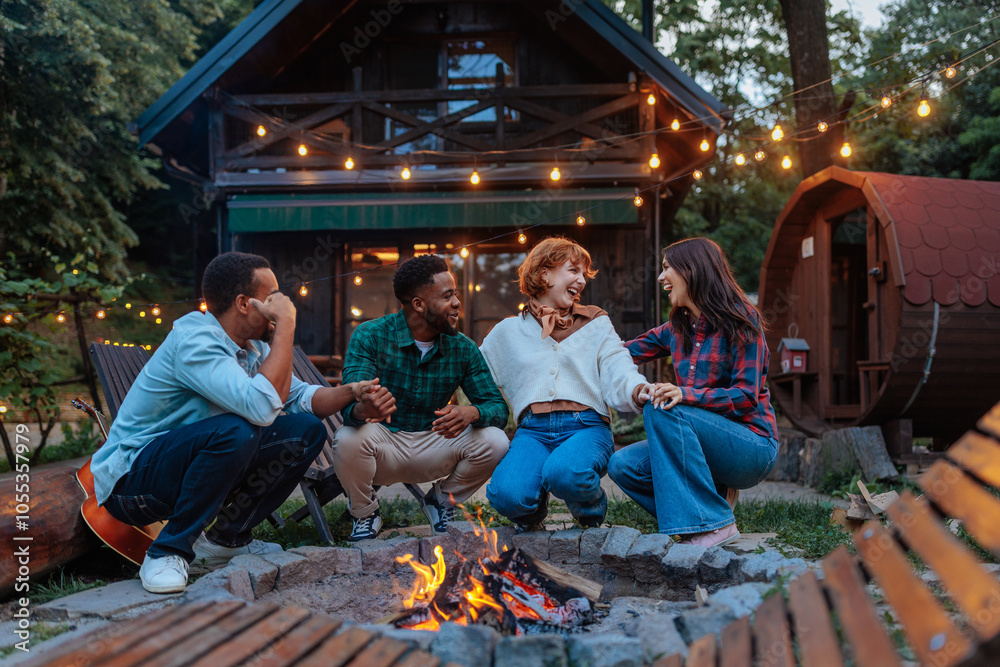 © bernardbodo - Friends kneeling next to a burning fire pit in a backyard © bernardbodo - Friends kneeling next to a burning fire pit in a backyard