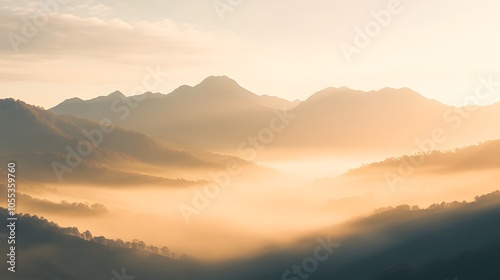 A misty mountain range at sunrise with soft light illuminating the peaks