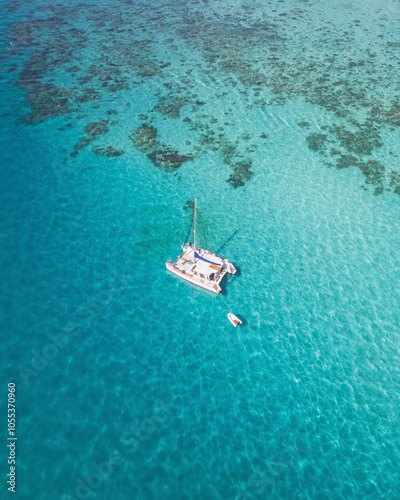 Aerial view of sailboat anchored in the turquoise ocean, Cairns, Australia.