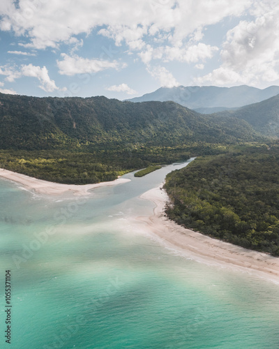 Aerial view of pristine beach and turquoise ocean surrounded by lush rainforest and mountains, Noah Creek, Daintree Rainforest, Queensland, Australia.