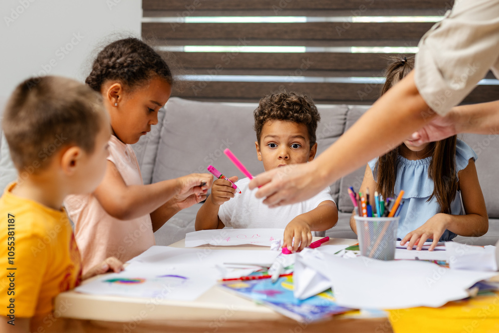 Children coloring together at a table with supplies. Children coloring together at a table with supplies.