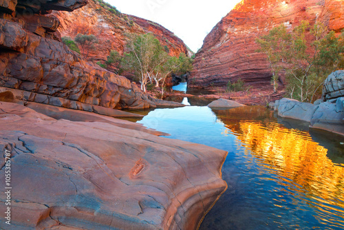 Aerial view of hamersley gorge with dramatic rock formations and tranquil water reflections, karijini national park, pilbara region, australia. photo