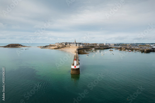 Aerial view of a beautiful lighthouse by the ocean with boats and a historic cityscape, Saint-Malo, France. photo