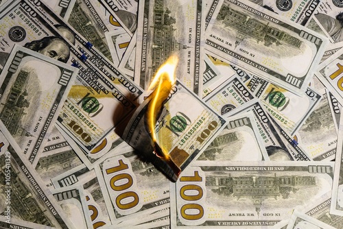 American currency banknote burns as a sign of a falling or rising currency rate