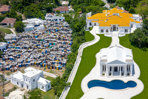 aerial view of socioeconomic divide between crowded shantytown and manicured gated community, poor vs rich