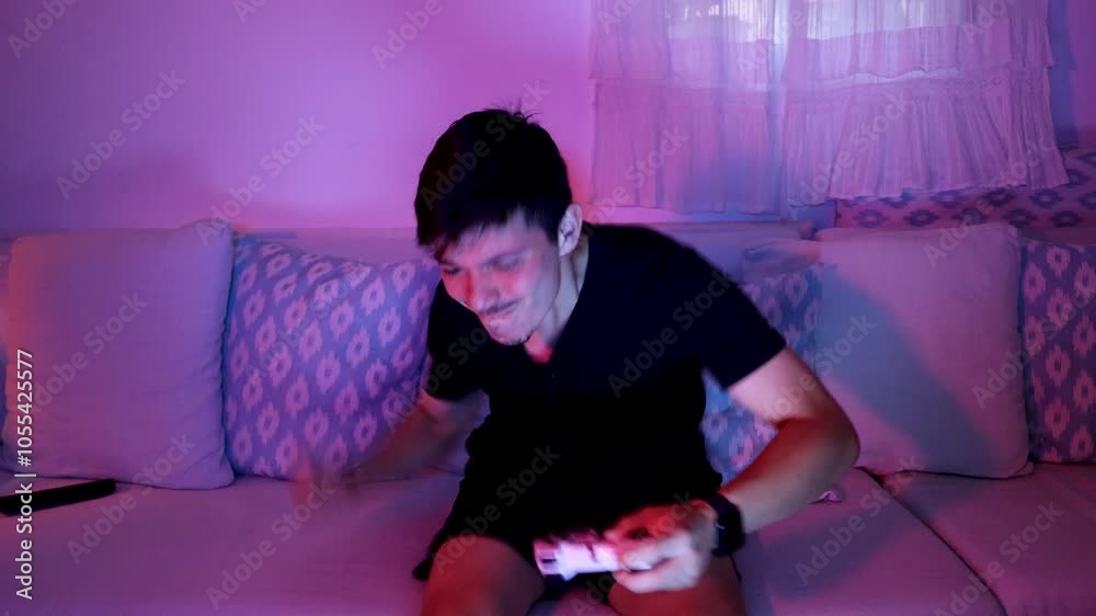 Young man angry at losing playing video games in his living room, home video games concept
