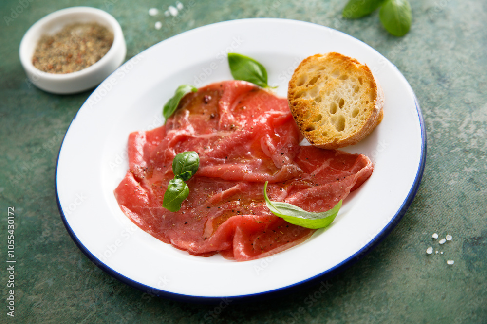 Traditional beef carpaccio with salt and pepper Traditional beef carpaccio with salt and pepper