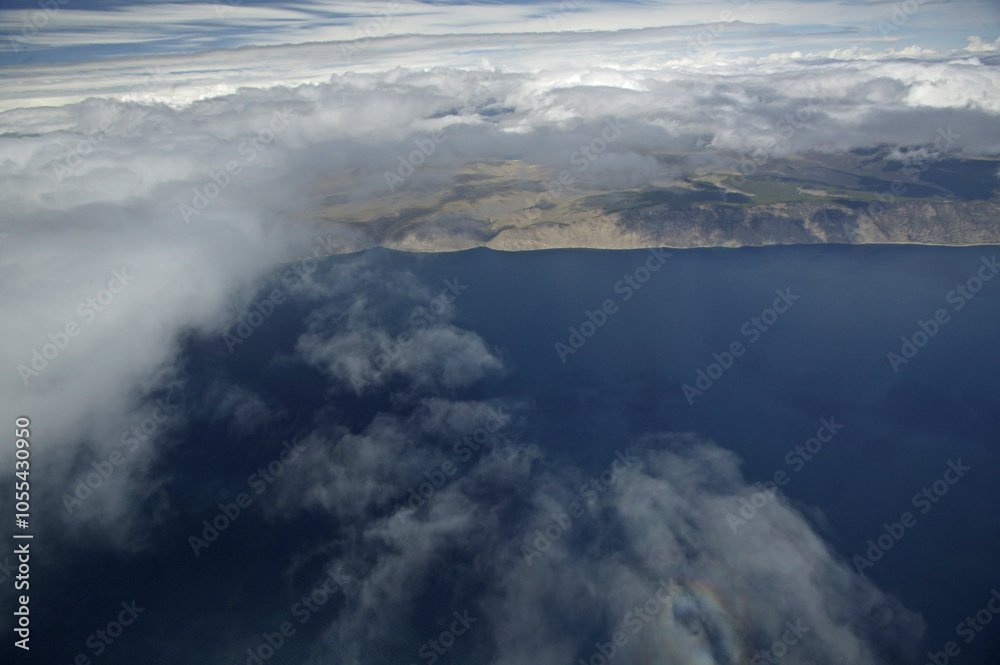 Aerial view of the pristine Baikal Lake surrounded by the majestic Primorskii Mountain Range under a tranquil sky, Irkutsk Oblast, Russia. Aerial view of the pristine Baikal Lake surrounded by the majestic Primorskii Mountain Range under a tranquil sky, Irkutsk Oblast, Russia.
