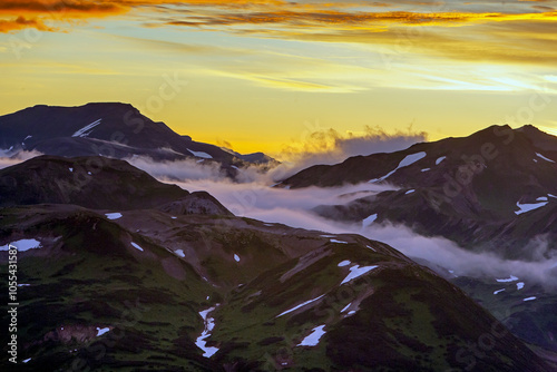 Aerial view of majestic mountains under a dramatic sunset with clouds, Kamchatka, Russia. photo