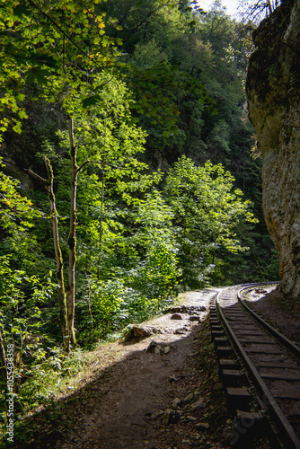 
A shelf of space was formed in the gorge and a railway was laid along it, along the rock. The sun enters the gorge and illuminates the rock ledge.