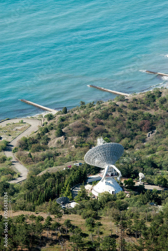 Aerial view of a beautiful radiotelescope near the coast surrounded by forest and sea, Crimea, Russia. photo