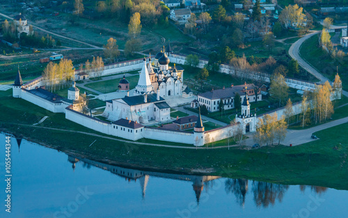 Aerial view of assumption abbey surrounded by trees and river, staritsa, russia. photo